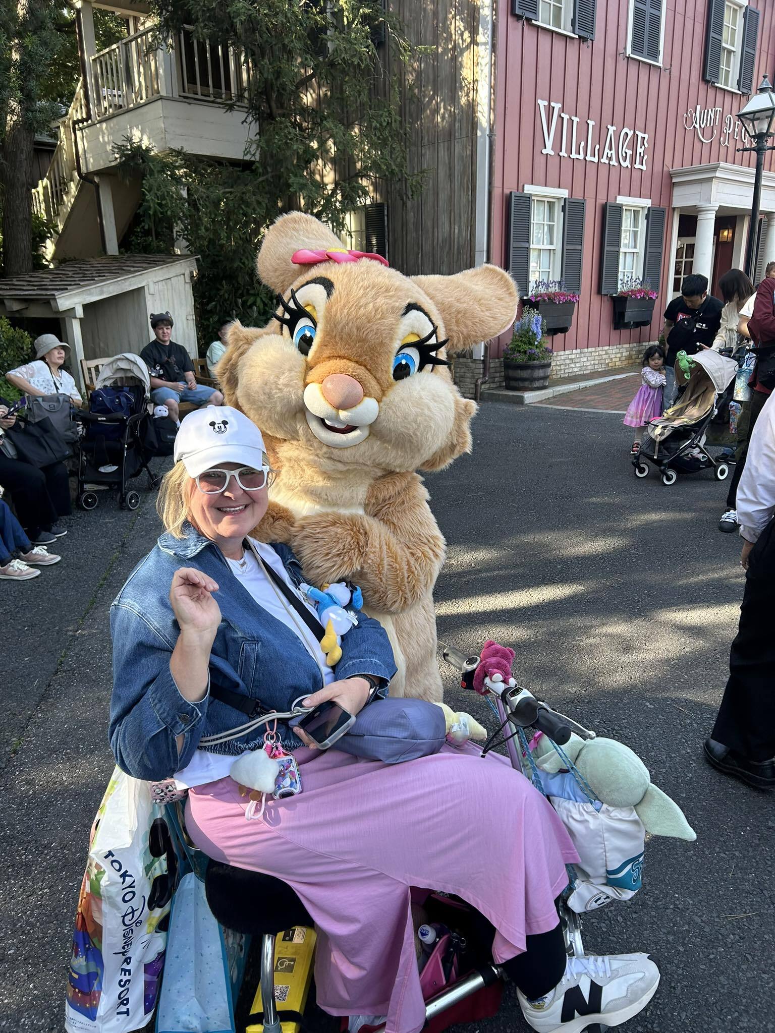 Woman at theme park on a mobility scooter with animal costume.