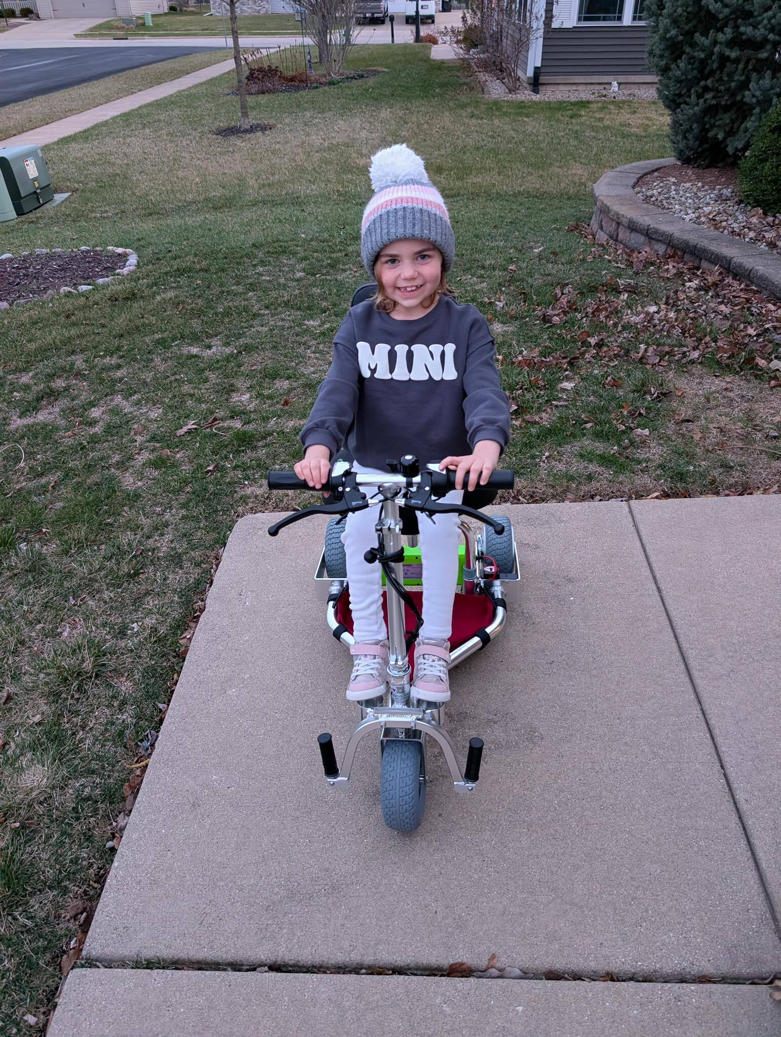 Girl on a mobility scooter smiling.