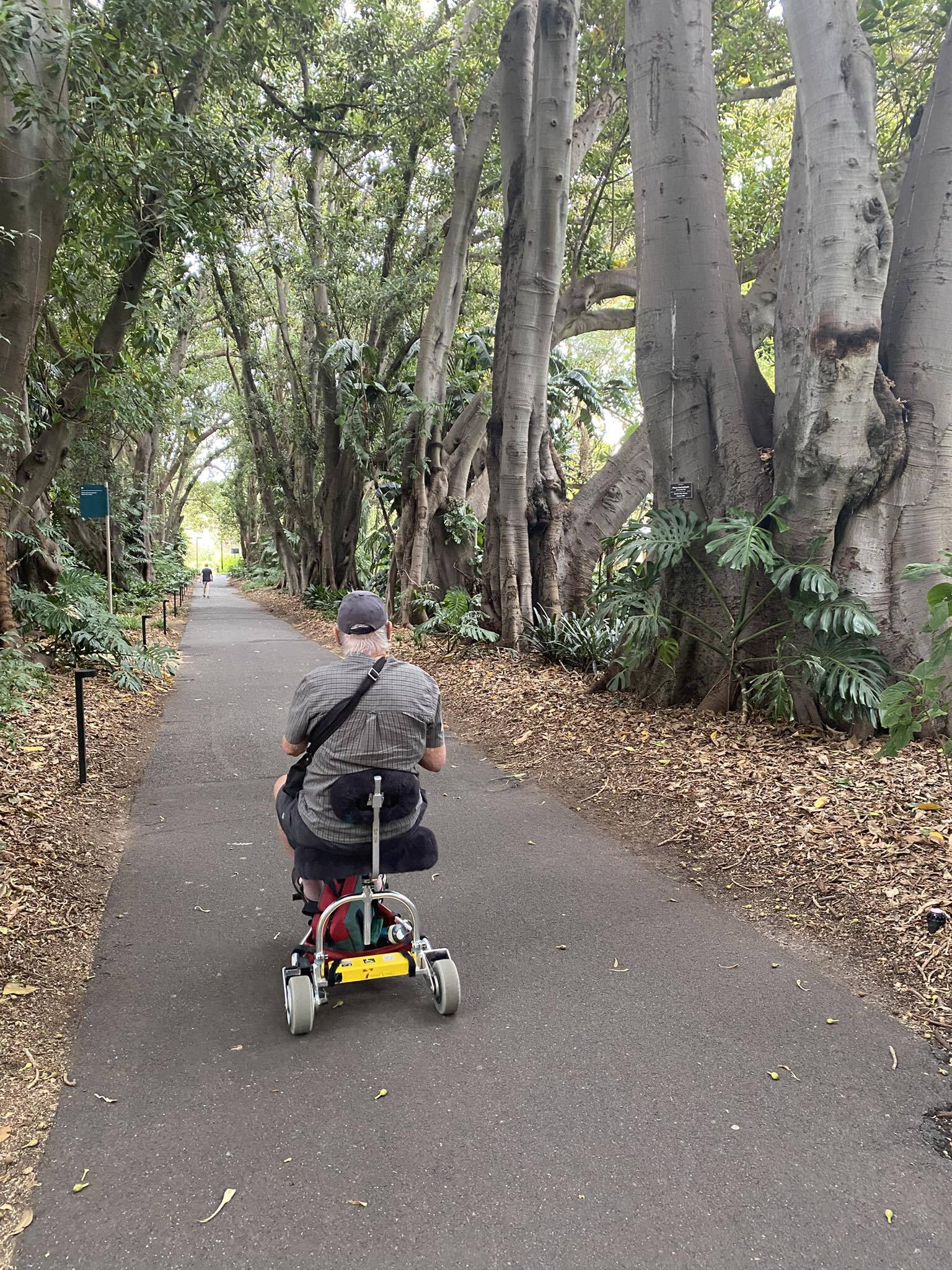 Man driving on a paved road in the woods.