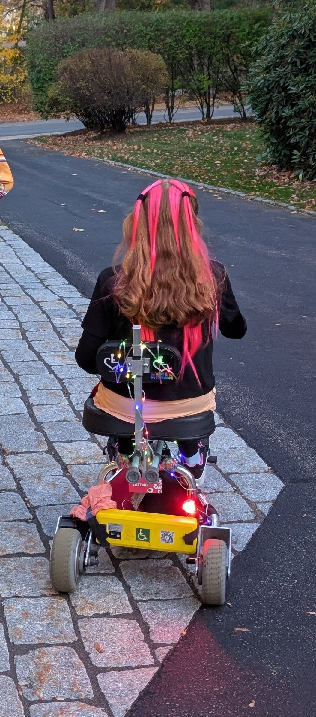 Woman on mobility scooter riding away.